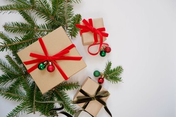 Christmas background with gift boxes and ornaments in white color. Xmas celebration, greetings, preparation for winter holidays. Festive mockup, top view, flat lay with copy space.