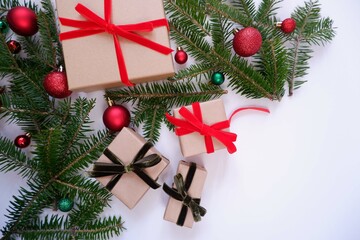 Christmas background with gift boxes and ornaments in white color. Xmas celebration, greetings, preparation for winter holidays. Festive mockup, top view, flat lay with copy space.