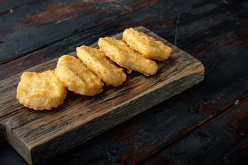 Chicken breast nuggets on old dark wooden table
