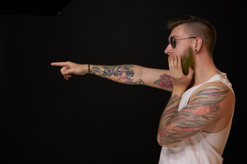 bearded man in white t-shirt with tattoos on his arms posing bully