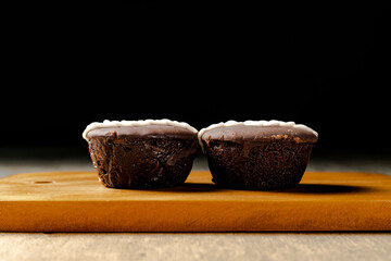 Two chocolates facing each other on a board and up close