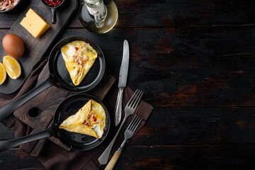 Fried breakfast omelette with crab meat and cheese, on frying iron pan, on dark wooden background, top view flat lay  , with copyspace  and space for text - obrazy, fototapety, plakaty