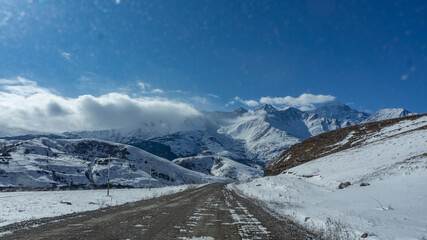 Fototapeta na wymiar road in the middle of the snow covered mountains