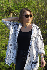 Smiling girl with light brown hair and a checkered shirt, sunny warm day.