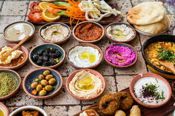 Delicious Turkish family breakfast table with pastries, vegetables, greens, spreads, cheeses, fried...