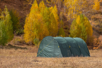 Large basecamp tents on colorful mountains background.