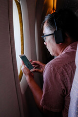 Male passenger using smartphone in an airplane