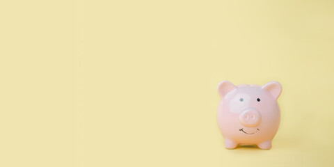 Pink piggy bank on yellow background with copy space, saving and investing Financial management and bank, wealth and financial concept.