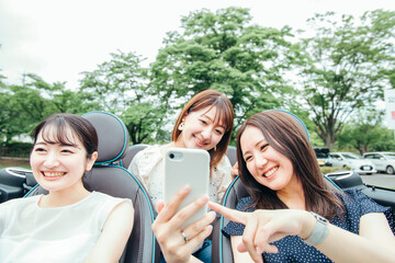 ドライブでスマホを使う女性たち
