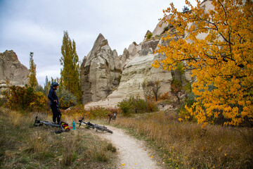 Cyclist riding a bike between gullies with dog