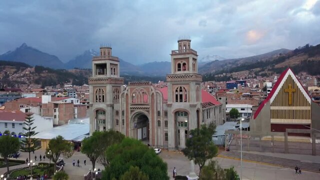 Aerial view from drone rising from the central square of Huaras seeing the cathedral of the diocese and the whole town and the mountains and snow-capped mountains in the background in the afternoon