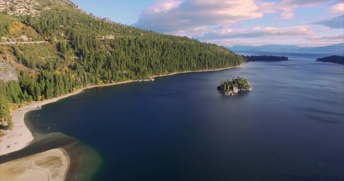 Aerial over shoreline and trees at Lake Tahoe emerald bay