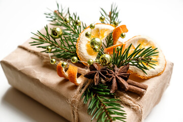 Christmas gift box decorated with fresh fir twigs, dried orange slices and peels and anise stars, eco styled