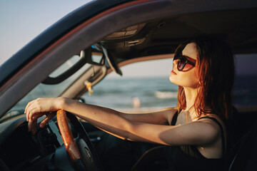 Obraz na płótnie Canvas pretty woman in sunglasses driving a car trip