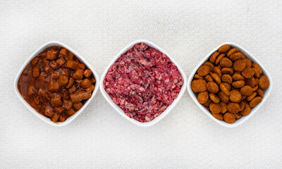 Selection of dogfood options, raw pets mince, chunks in gravy and dry kibbles
