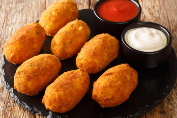 Croquetas de Bacalao Cod Croquettes with sauces close up in the slate plate on the table. Horizontal