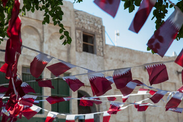 Naklejka premium Doha,Qatar,05,10,2019. Old market Souk Waqif decorated with Qatar national flags.