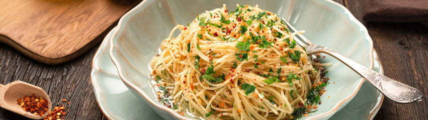 Close-up plate of freshly cooked spaghetti AGLIO E OLIO banner panoramic