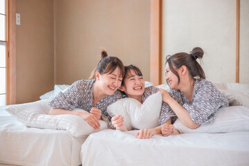 女子旅・布団でくつろぐ女性たち（相談）
