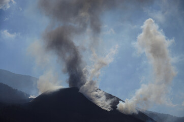 Erupting volcano, clouds of steam, ash and blue sky in the background, La Palma, Canary Islands
