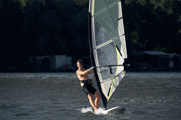 Windsurfer surfing on a windy day at the city river.