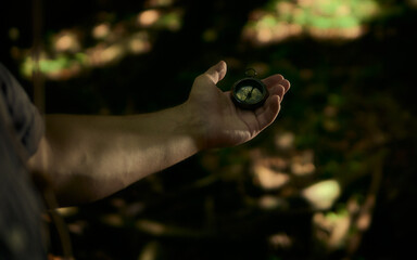 The guy holds a compass in his hand. The guy is exploring the jungle. Travel, adventure, expedition.