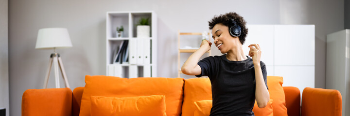 African American Woman Enjoying Music Through Headphones In