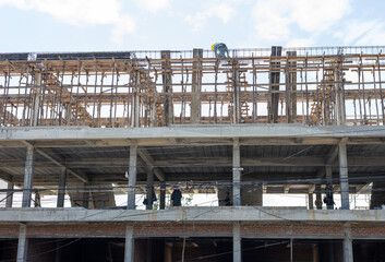 A view from below to the construction of a rowhouse building anchored.