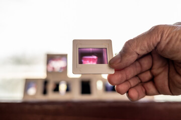 A close-up view of the 35mm slide film in middle-aged fingers.