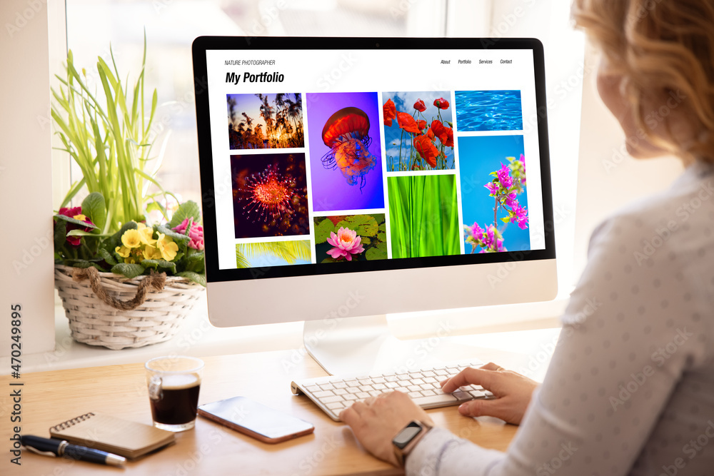 Wall mural woman viewing photography portfolio website on computer screen