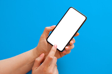 Person using mobile phone with blank screen on blue background