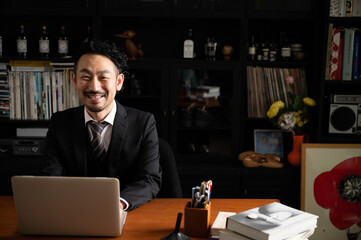 Handsome Asian (Japanese) businessman smiling at the camera, copy space at right