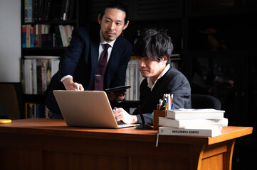 Obraz na płótnie Canvas 部下と話す事務所の代表っぽい日本人の（アジア人）イメージ　コピースペースあり