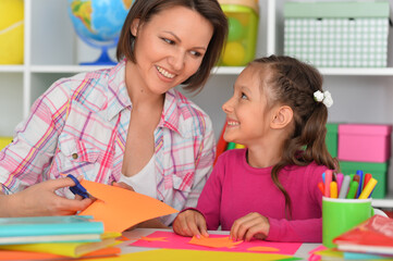 Fototapeta premium Mother teaches her cute daughter to do craft items