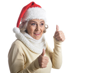 Fototapeta na wymiar Portrait of senior woman in Santa hat showing thumbs up