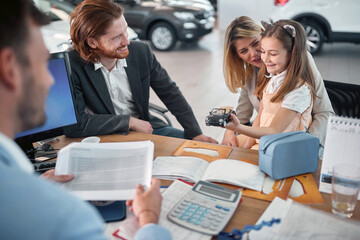 Happy family in car dealership choosing their  car