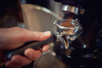 Taking a measure of ground coffee from apparatus for making a espresso. Coffee, beverage, bar