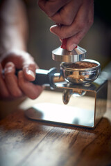 Fototapeta na wymiar Close-up view of a barman's hands using accessories for preparing an espresso. Coffee, beverage, bar