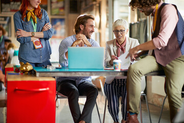 A group of colleagues is analyzing some documents at work in the office