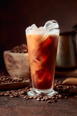 Ice coffee with cream being poured into it showing the texture and refreshing look of the drink.