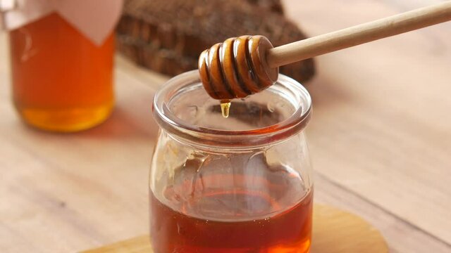 close up of fresh honey with spoon on table 
