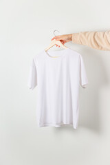 White t-shirt mockup in woman hand. Bella canvas mock up in minimal style.