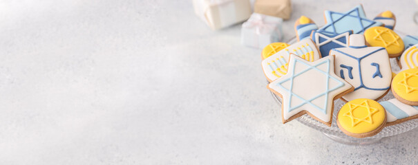 Dessert stand with tasty cookies for Hanukkah celebration on grey background with space for text