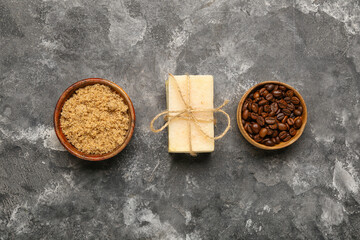 Fototapeta na wymiar Bowls with coffee beans, scrub and soap bar on dark background