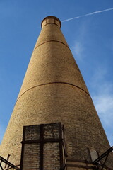 Chemin&eacute;e d'usine en briques. Ciel bleu.