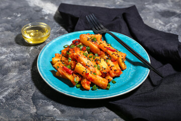 Plate with honey chilli potato on grunge background