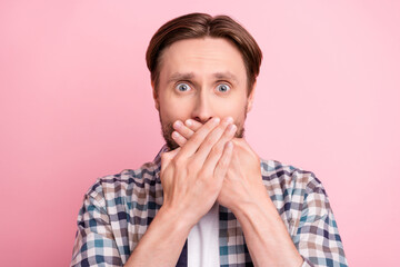 Photo of young man afraid worried nervous cover lips hands tell secret information isolated over pink color background