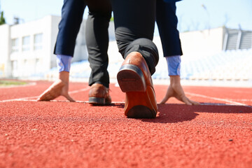 Businessman in starting position in stadium