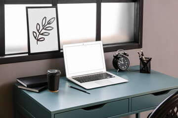 Fototapeta premium Comfortable workplace with laptop near window in interior of room