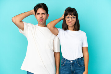 Young mixed race couple isolated on blue background with an expression of frustration and not understanding